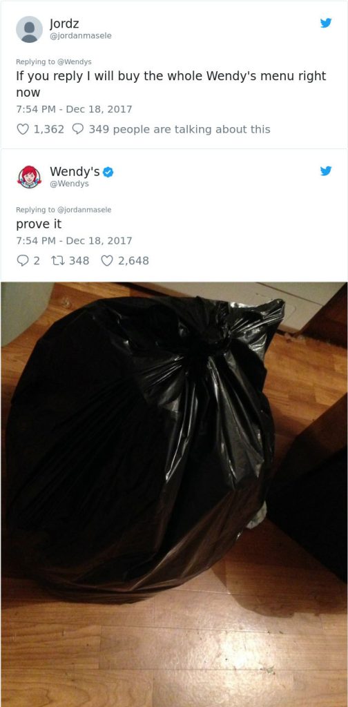 Twitter image of Wendy's replying to a Tweet sent to them that reads "if you reply I will buy the whole Wendy's menu right now." Wendy's replied with "prove it" with an attached picture of a black trash bag, signifying that all of their menu items are in the bag. 