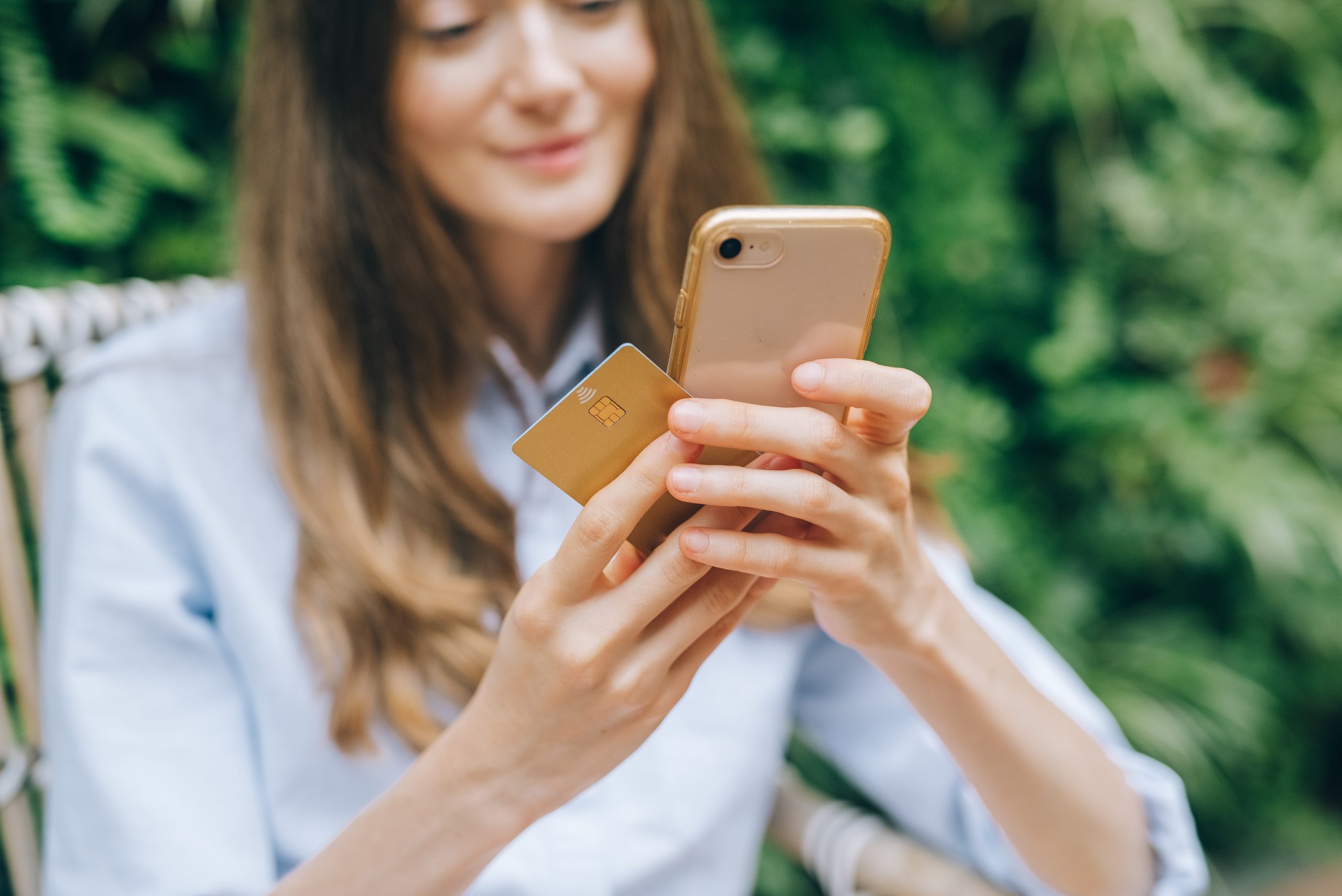 woman holding credit card and phone