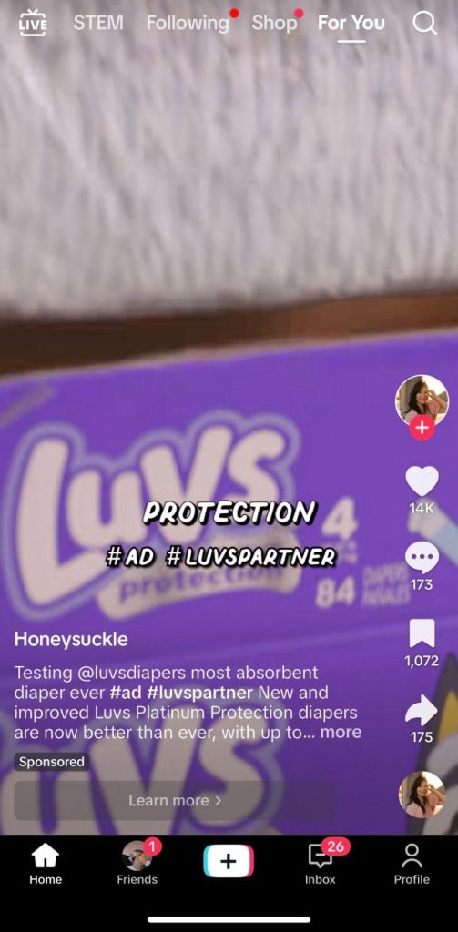 The image is a screenshot from an influencer's TikTok post about Luv's Platinum Protection diapers. On her post, there are the words that read "sponsored" in the bottom left corner, indicating that she was paid to post about Luvs's product. 