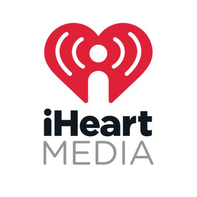 iHeartMedia's company logo consists of a white background with the bold, black text: "iHeart" and the skinny, uppercase, gray text: "MEDIA" below it. Above "iHeart" is a red heart with a lowercase, white i in the center, giving off radio waves/frequencies.