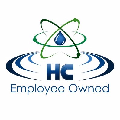 Hydro-Chem Systems' company logo consists of a white background with a green and blue neutron with a blue water drop as the nucleus. Below that is the dark blue letters H and C with blue rings coming out from either side of it (looking like the rings of Saturn.) Underneath is the blue text "Employee Owned."