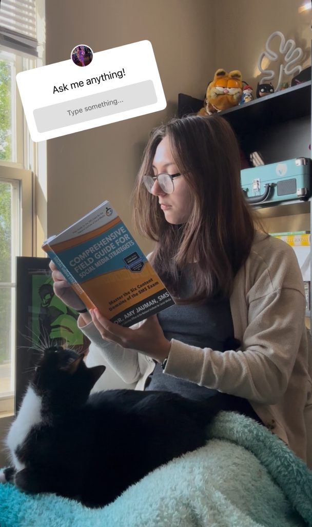 Photo of girl holding book with the Instagram sticker: Ask-Me-Anything!