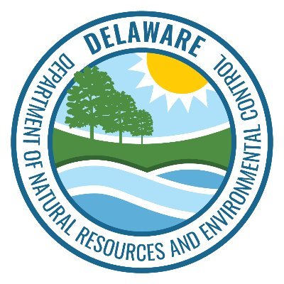Delaware Department of Natural Resources and Environmental Control's company logo consists of an emblem showcasing trees, a grassy field, the sun, and water. Wrapping around that image is the light blue text "Delaware Department of Natural Resources and Environmental Control."