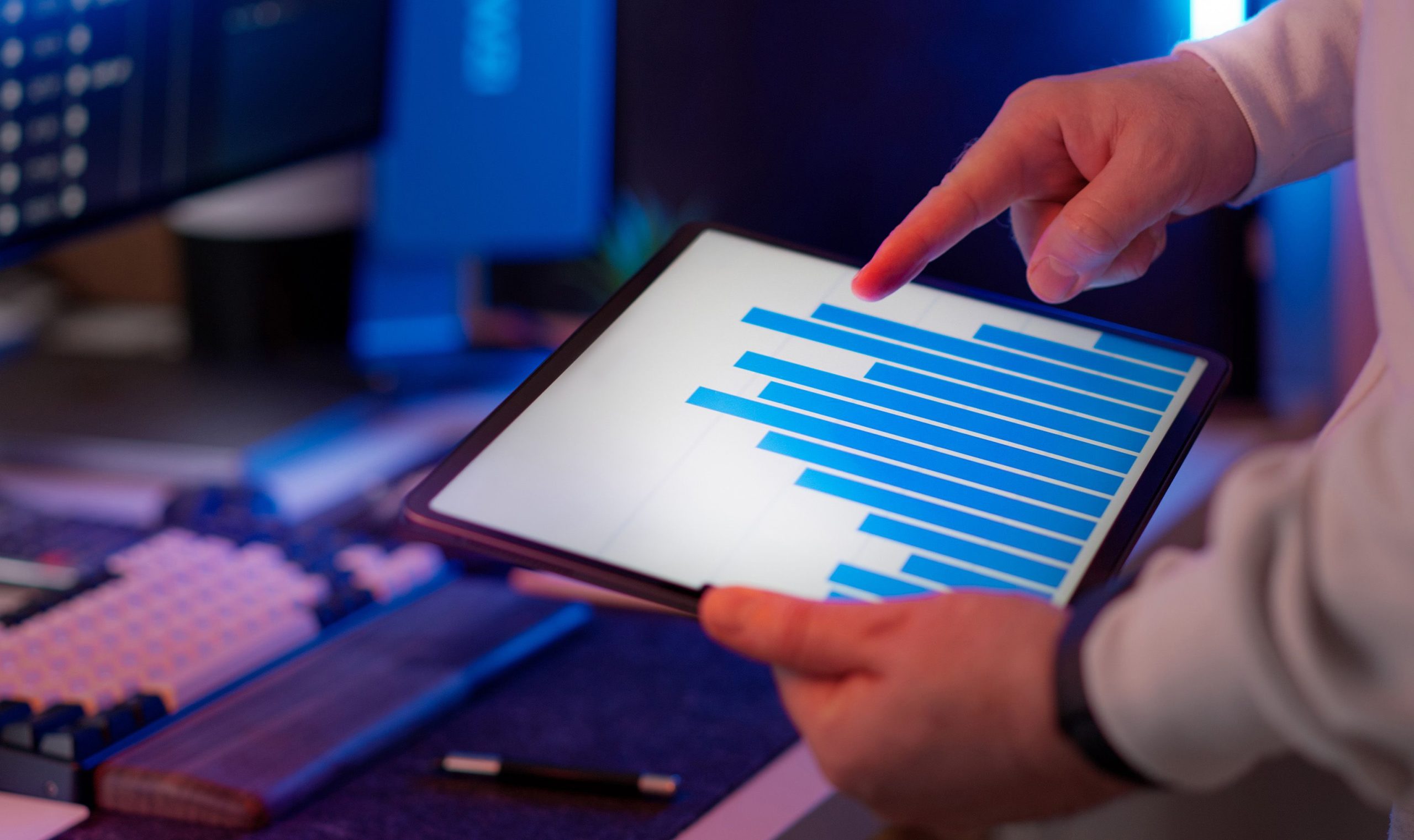 pexels-jakubzerdzicki-37685036 Business professional analyzing bar chart on tablet in office setting, highlighting data insights.